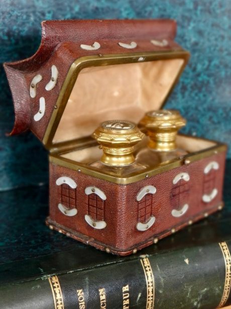 A pair of scent bottles in a leather and mother of pearl case