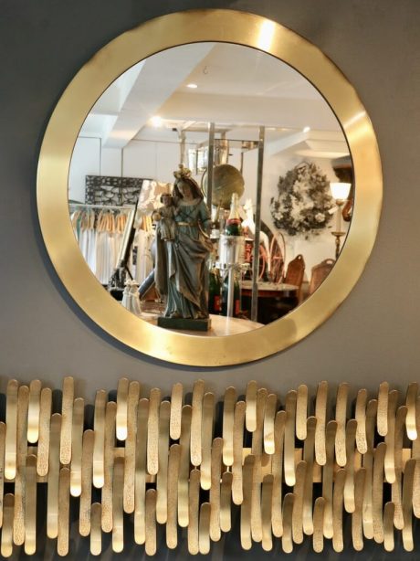 A vintage brushed brass circular mirror