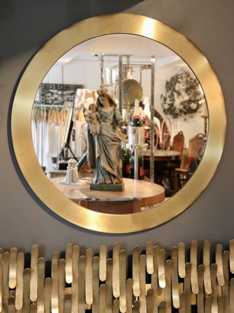 A vintage brushed brass circular mirror